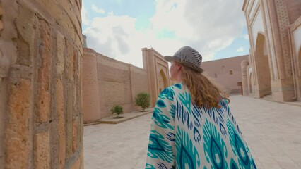 Wall Mural - Woman in ethnic dress near Madrassah in Ichan Kala of Khiva