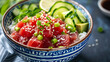 A vibrant bowl of poke featuring diced tuna avocado cucumber and sesame seeds over steamed rice drizzled with soy sauce.