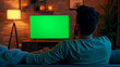 © Studio Nova - person from behind watching a large screen TV with a green screen