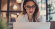 © Stream Skins - businesswoman with glasses working on laptop in the office