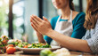 woman's hands clasped in prayer, conveying gratitude and spirituality before a meal