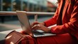 © Svetlana - a woman in a red suit is typing on a laptop at the airport. businessman in the terminal with luggage. work online