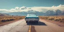 Vintage And Retro Photo Of A Classic Car Parked On A Deserted Road, With Mountains In The Backdrop