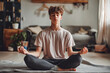 © VisualProduction - One teen man doing guided meditation yoga self care practice at home. He practices yoga through online content. He likes yoga because it keeps him calm.