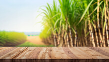 The Empty Wooden Brown Table Top With Blur Background Of Sugarcane Plantation. Exuberant Image., For Montage Or Display Products