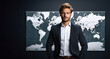 © YannTouvay - Handsome young businessman standing in front of world map and looking at camera