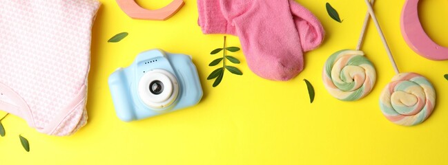 Wall Mural - Flat lay composition with toy camera on yellow background, space for text. Future photographer