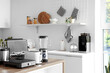 © Pixel-Shot - Set of modern appliances on wooden table in contemporary kitchen