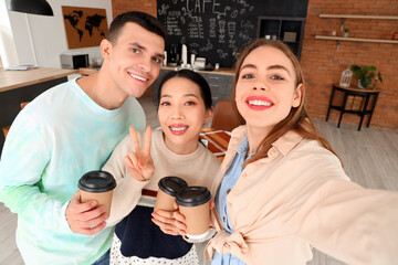 Wall Mural - Young people with coffee cups taking selfie in cafe