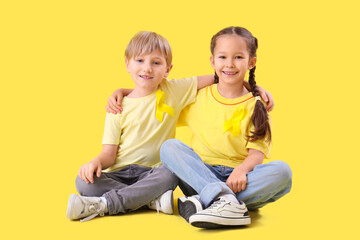 Sticker - Cute little children with yellow ribbons on color background. Childhood cancer awareness concept