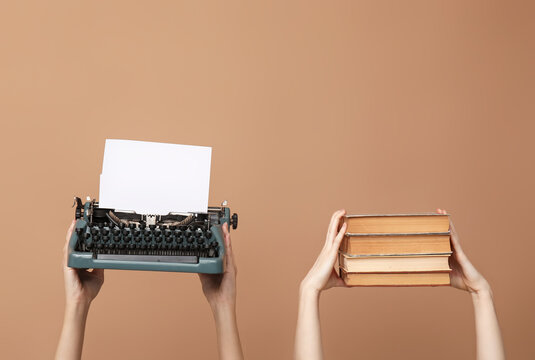 Women with vintage typewriter and books on brown background
