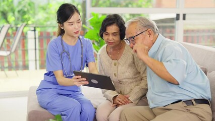 Wall Mural - Beautiful Asian nurse or doctor use tablet to consult and give assistant to couple senior man and woman in living room of clinic or hospital in senior healthcare center.