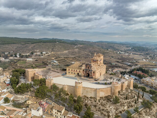 Wall Mural - Aerial view of Caravaca de la Cruz castle dominating the landscape with square and circular towers, medieval palace and Baroque ornament facade church