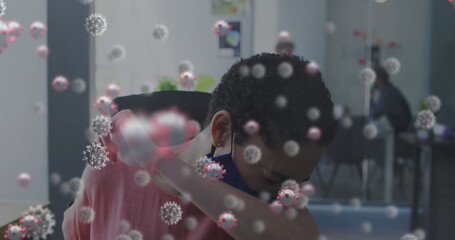Poster - Multiple covid-19 cells floating against woman wearing face mask sneezing at office