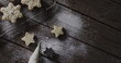 Star-shaped cookies dusted with sugar on a dark wooden table