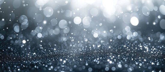 Sparkling silver particles with bokeh creating an abstract background. Festive dust for Christmas and New Year.