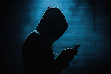 Dark silhouette of a mysterious Scammer in a hoodie holding a phone, symbolizing secretive communication or illegal activity.