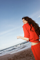 Joyful Woman Dancing by the Sunny Beach, enjoying the Freedom and Happiness in a Summer Fashion Trend