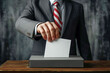 Close-up of businessman putting ballot in ballot box. Election concept