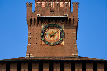 Wall Mural - Close up of the clockface at the clock tower of the Castello Sforzesco (Sforzesco Castle) on a clear sunny fall day in Milan, Italy