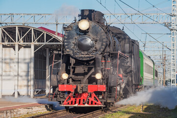 Wall Mural - Retro steam train approaches to the platform.