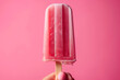popsicle or freezie fruit ice cream on a stick against a pink background