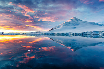beautiful antarctica landscape, mountains next to the sea with breathtaking reflection during midnig
