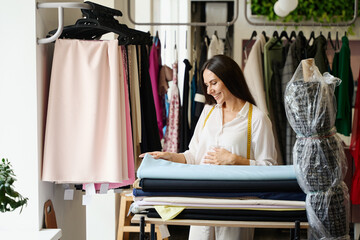 Woman in a sewing workshop chooses fabric