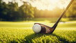 Golf club and golf ball on green grass with sun flare .