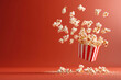 spilled popcorn from classic container on red backdrop