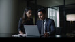 © Moritz - Collaborative Synergy in Diversity: Enthusiastic Latin Businessman and Asian Businesswoman Engaging in Productive Partnership, United in Strategy and Innovation over Laptop in Corporate Office Setting