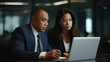 © Moritz - Collaborative Synergy in Diversity: Enthusiastic Latin Businessman and Asian Businesswoman Engaging in Productive Partnership, United in Strategy and Innovation over Laptop in Corporate Office Setting