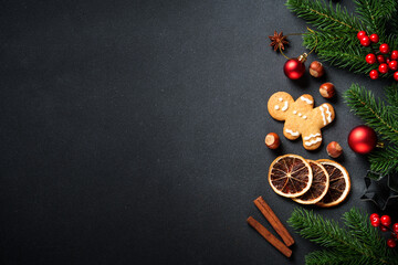 Wall Mural - Gingerbread cookies, spices and Christmas decorations at black. Top view with space for text.