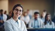 Capturing the essence of confidence and professionalism, a female doctor or nurse stands in the front row of a medical training class or seminar room, smiling cheerfully, with ample copy space