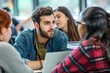 © Straxer - A group of male and female students sitting with the professor and discuss ideas.
