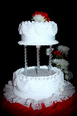 White wedding cake in two layers, with black background.