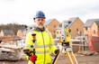 © Iryna - Surveyor builder site engineer with theodolite total station at construction site outdoors during surveying work