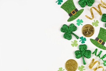 Poster - St Patricks Day side border of green shamrocks, leprechaun hats, gold coins and ribbon. Above view over a white background with copy space.