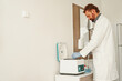 © Daria - Male scientist in uniform and mask putting a small plastic test tube in a microcentrifuge