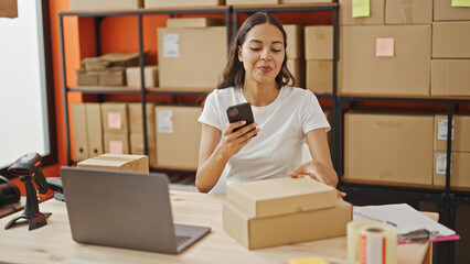 Wall Mural - African american woman ecommerce business worker make photo to packages by smartphone at office