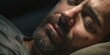 A close-up view of a man peacefully sleeping with his eyes closed. Suitable for various sleep-related themes and concepts