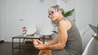 © Krakenimages.com - Mature hispanic woman with short grey hair squeezing a stress ball in an indoor waiting room.