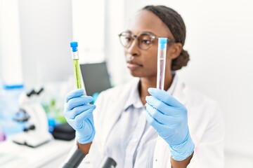 Canvas Print - African american woman scientist holding test tubes at laboratory