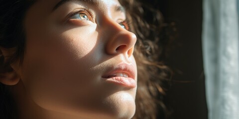 Aufkleber - A close-up of a woman looking out a window. This image can be used to depict curiosity, introspection, or longing