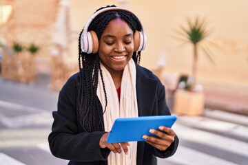 Sticker - African american woman smiling confident using touchpad and headphones at street