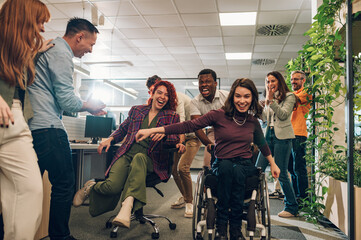 Wall Mural - African man pushing a woman with disability and winning the office chair race