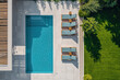 Aerial view of a luxurious backyard with a pristine swimming pool, sun loungers lined up neatly on a tiled poolside, surrounded by lush green grass.