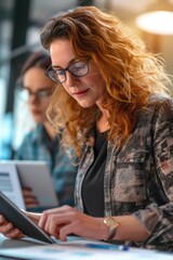 Aufkleber - A woman wearing glasses is using a tablet computer. This picture can be used to illustrate technology, internet browsing, or digital communication