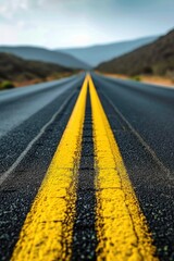 Poster - A scenic view of a yellow line on a road with majestic mountains in the background. Suitable for travel, adventure, and road trip concepts