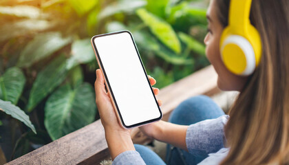 woman with headphones holds mockup smartphone, exuding modernity and connectivity